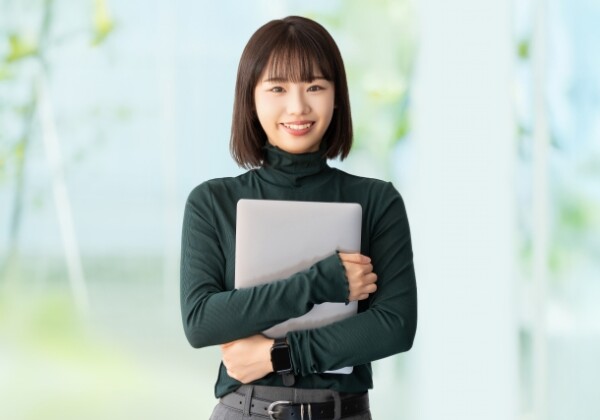 ノートPCを抱きしめる女子大生