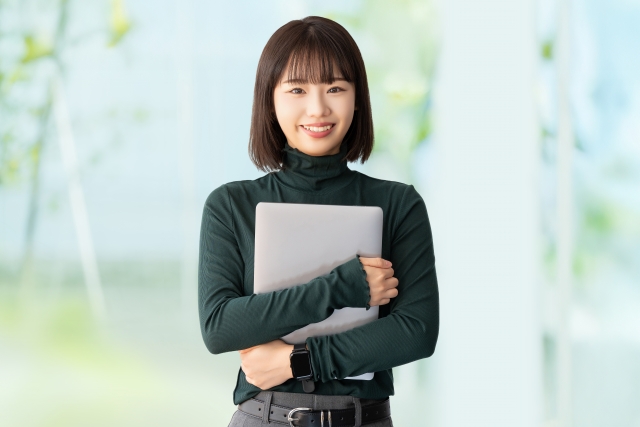 ノートPCを抱きしめる女子大生