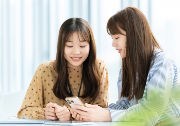 スマホで登録作業をしている学生