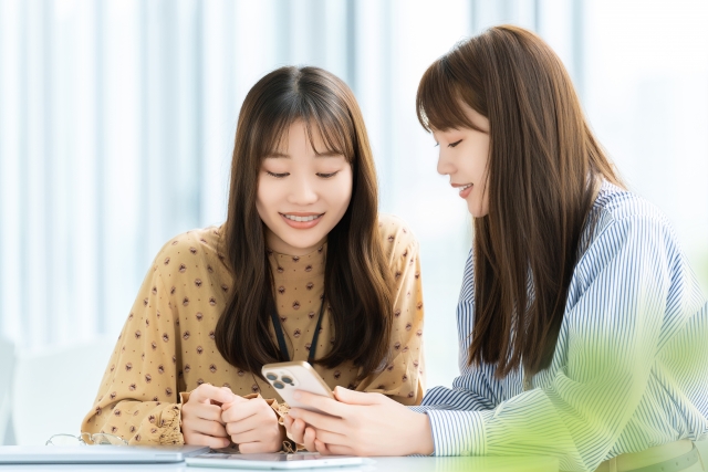 スマホで登録作業をしている学生